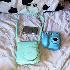 A blue Polaroid camera with a bag and film to go .